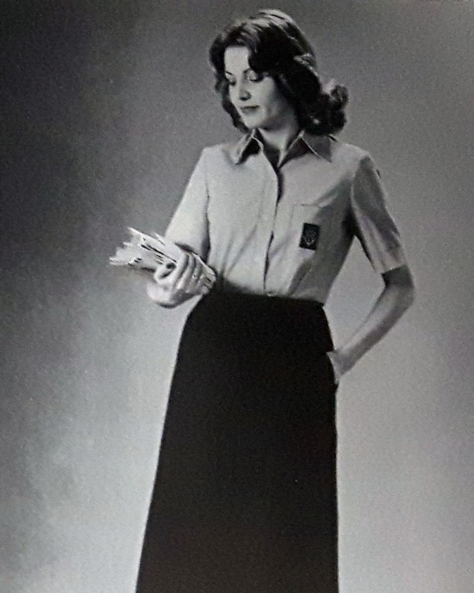 Eine Frau mit einem Stapel Briefen in der Hand.