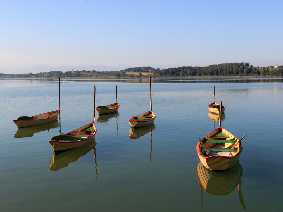 Stehende Boote auf dem spiegelglatten See.