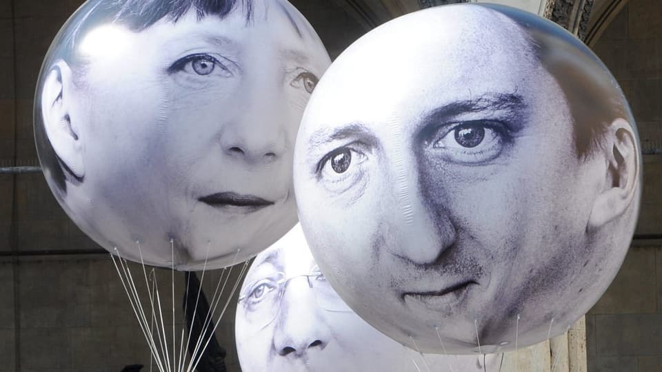 Ballone mit dem Aufdruck von von Angela Merkels und David Camerons Gesichtern an einer Protestkundgebung im München gegen den G7-Gipfel. 