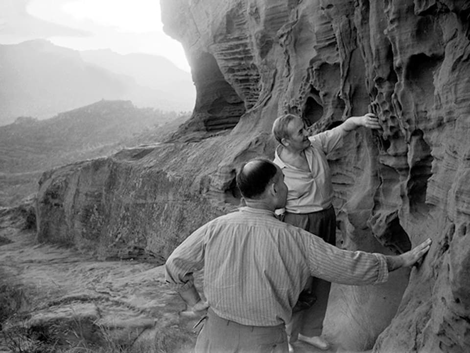 Zwei Männer bei einer Felsformation. 