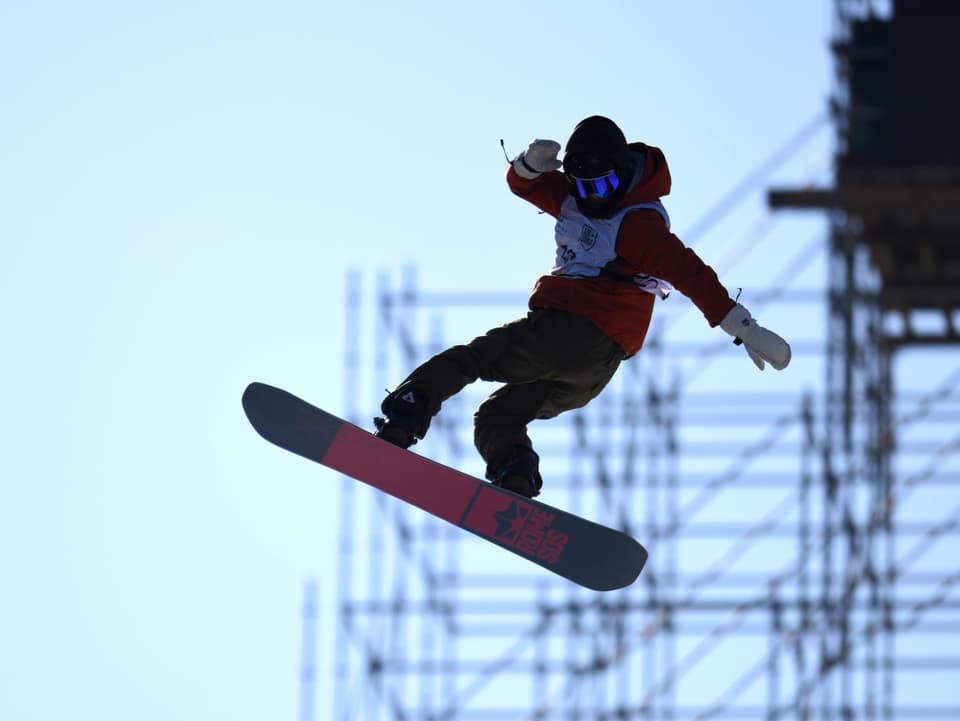 Snowboarder fliegt durch die Luft.