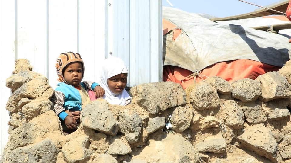 Zwei Kinder bei einem Flüchtlingszelt.