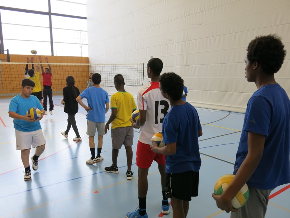 Jugendliche Asylsuchende beim Volleyballspiel.