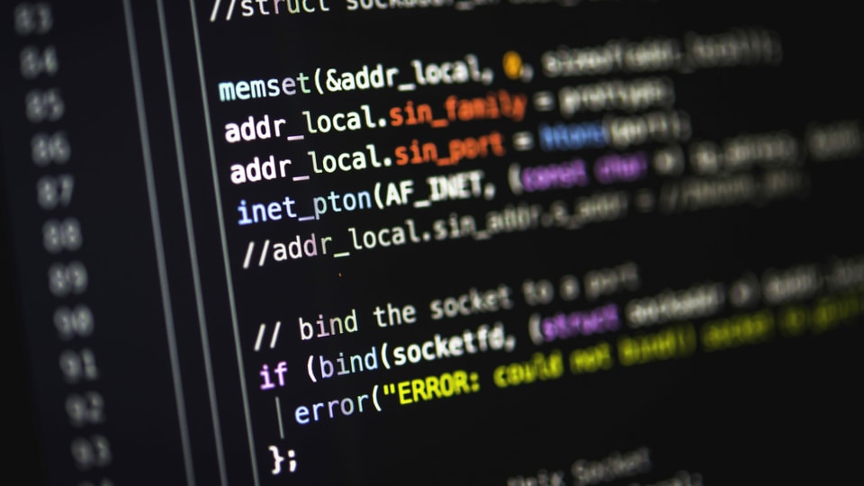 Bildschirm mit Programmier-Quellcode auf schwarzem Hintergrund