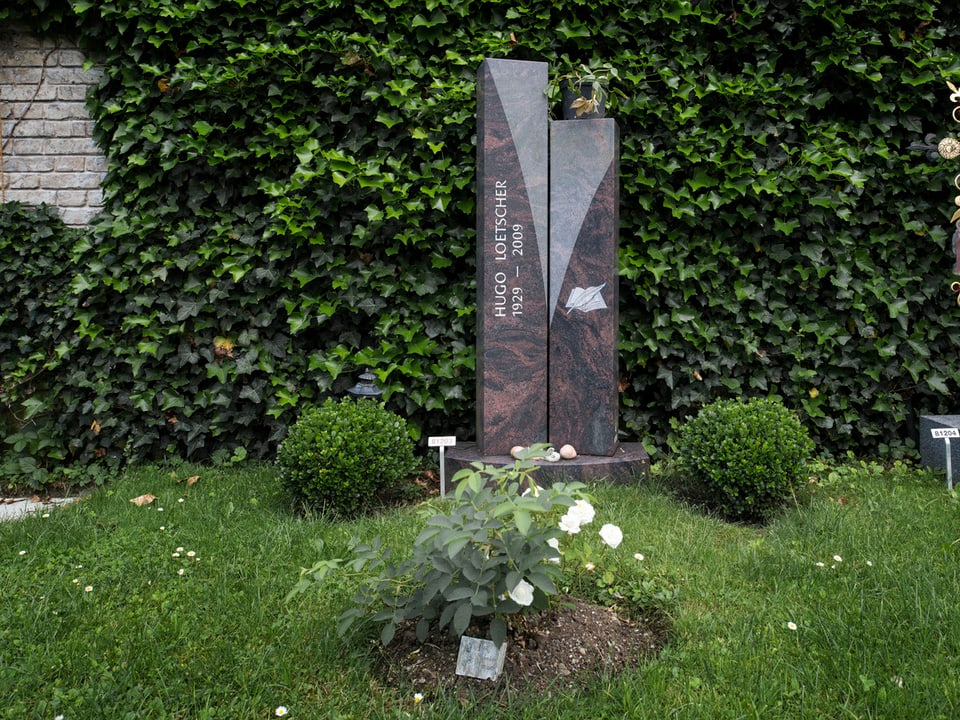 Grabstein von Schriftsteller Hugo Loetscher auf dem Friedhof Sihlfeld in Zürich. Schlichter in der Mitte gespaltener Marmorstein.