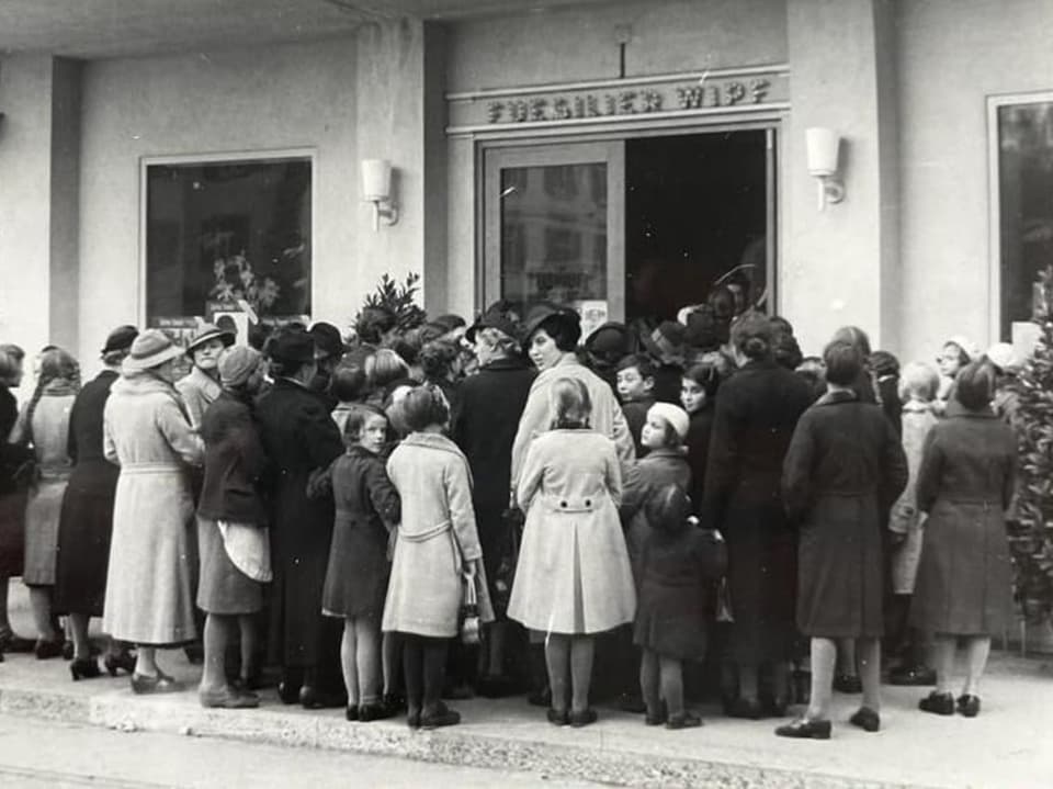 A black and white photo shows crowds streaming into the cinema for a film in 1938.