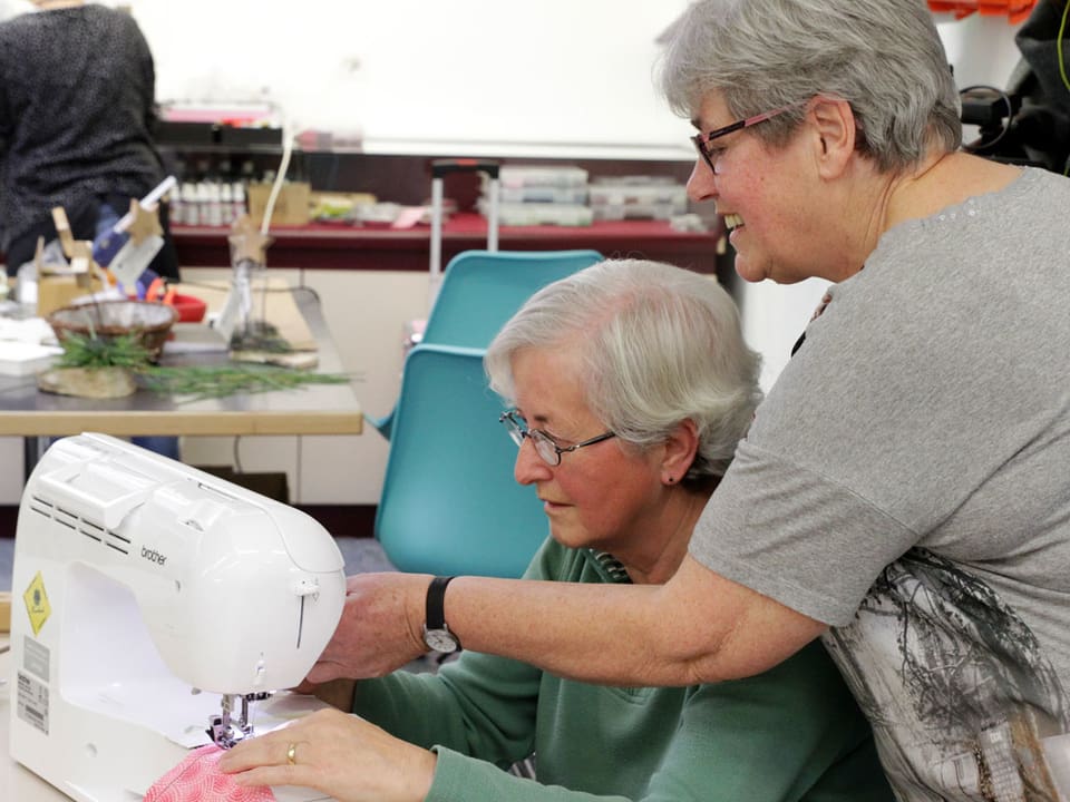Anita Witschi arbeitet mit einer Frau an der Nähmaschine.