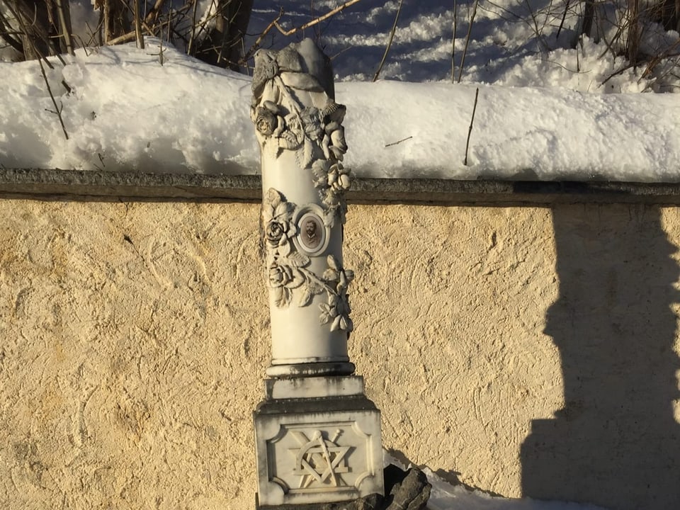 Verzierter Grabstein unter Schneedecke