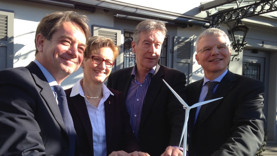 Die drei Chefs der Energieversorger und Regierungsrätin Pegoraro posieren vor kleinem Windradmodell. 