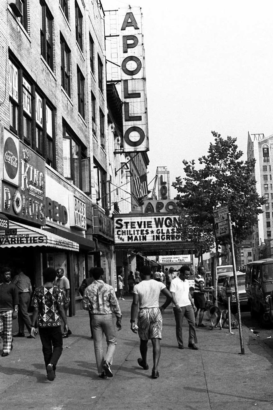 Junge Leute spazieren vor dem Apollo Theater im New Yorker Stadtteil Harlem.