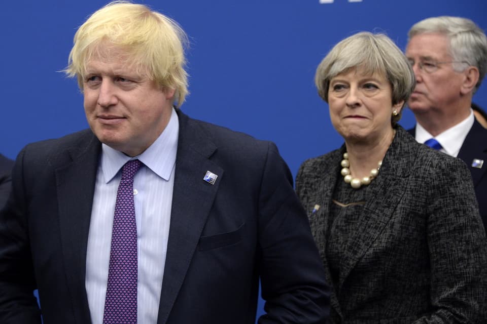 Boris Johnson läuft vor der damaligen Premierministerin Theresa May in einen Saal hinein.