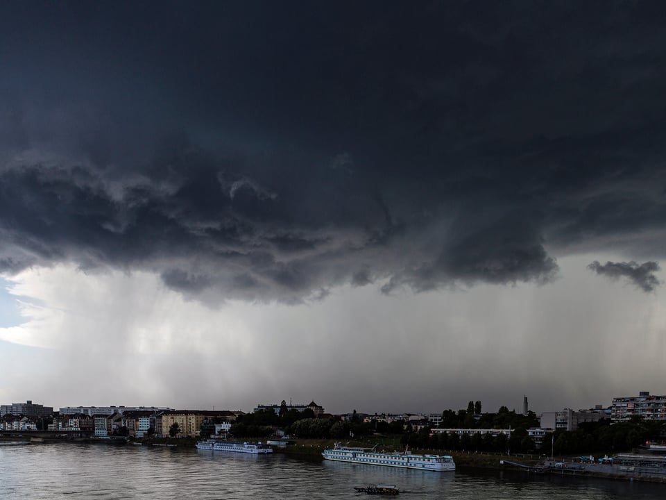 6. Juli Im Vordergrund der Rhein, im Hintergrund eine Gewitterzelle.