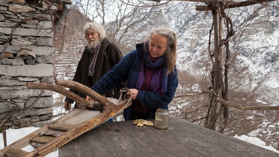 Ulrico und seine Frau Sanna basteln an einem Gegenstand aus Holz herum.