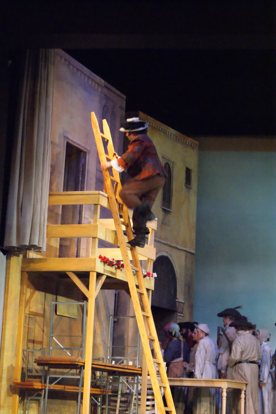 Mann auf Leiter, die an Balkon angelehnt ist.