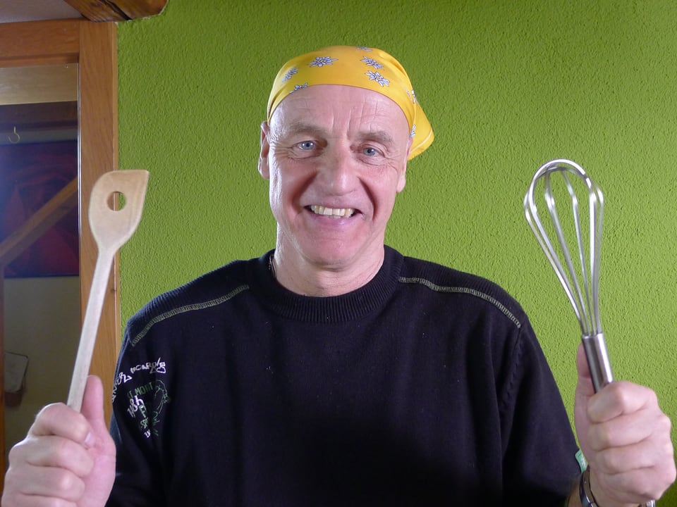 Rolf mit Küchenutensilien in den Händen.