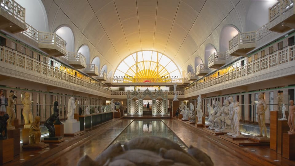 Eine grosse Halle mit Gallerie und Balkonen und etlichen Statuen.