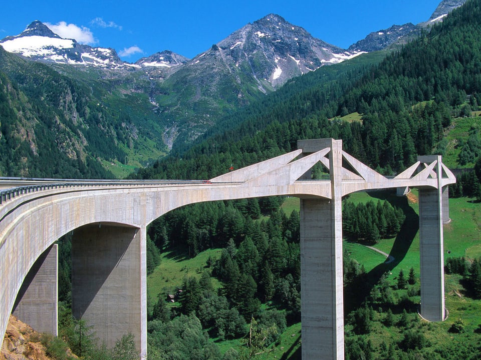 Eine Brücke in grüner Berglandschaft.