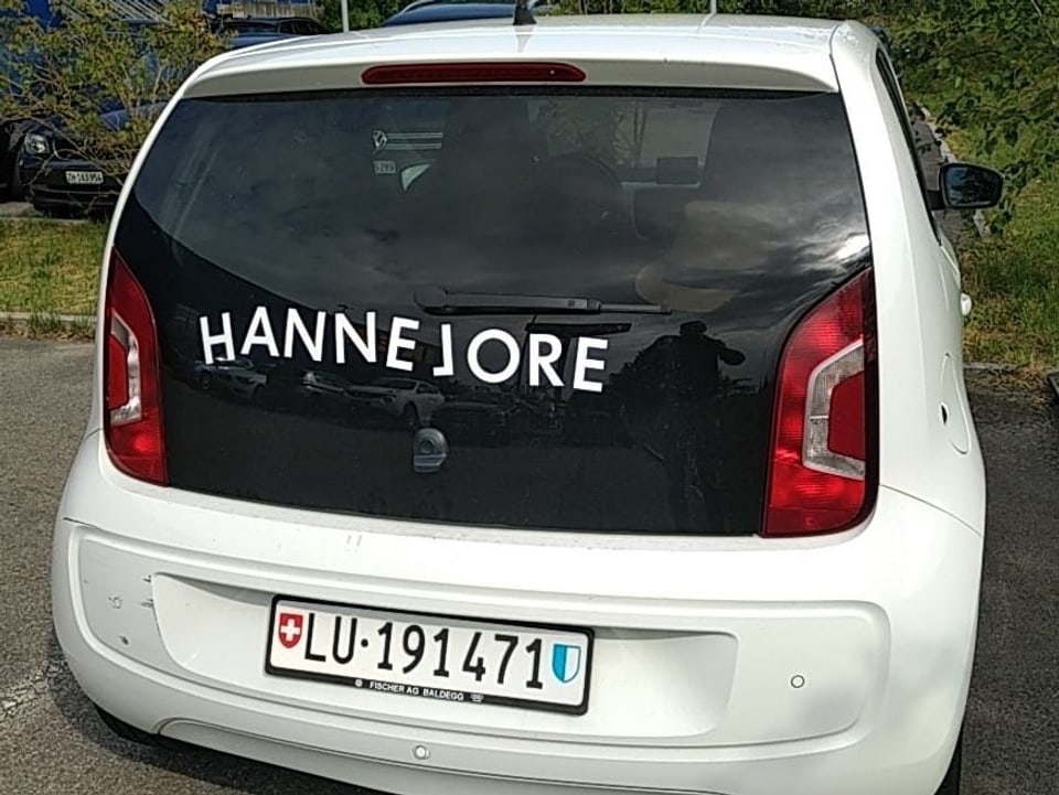 Ein weisses Auto von hinten fotografiert. Auf der Rückscheibe steht «HANNELORE».
