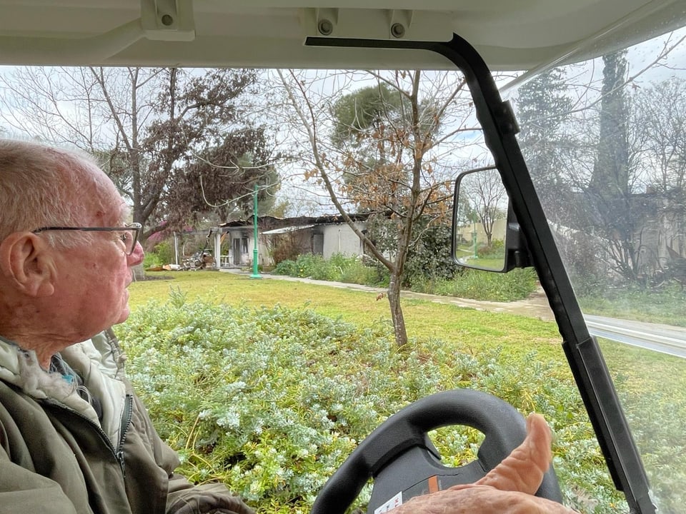 Ein alter Mann in einem Golf-Wagen