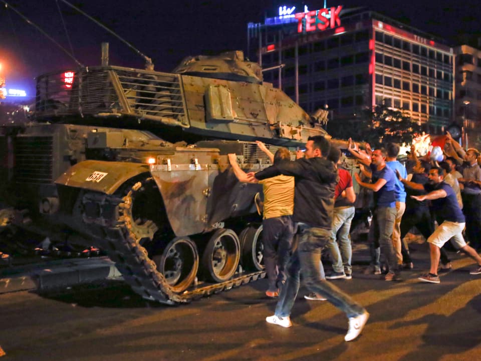 Zivilisten gehen auf einen Panzer los.