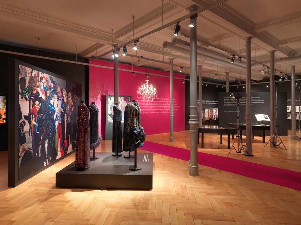 Ausstellungsraum im St. Galler Textilmuseum mit Fotowand und vier Kleiderpuppen