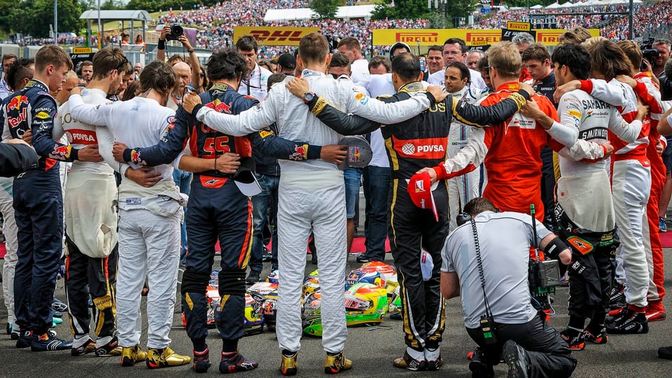 Die Formel-1-Fahrer aller Teams bilden beim GP Ungarn einen Kreis und umarmen sich, in der Mitte liegen die Helme der Piloten