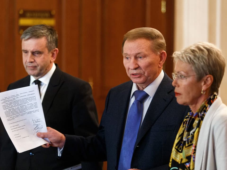Russlands Botschafter in der Ukraine, Michail Surabow, der frühere ukrainische Präsident Leonid Kuchma und die Schweizer Diplomatin Heidi Tagliavini treten vor die Medien.