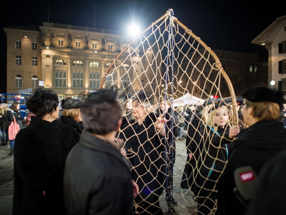 Frauen marschieren mit einem Netz ein auf dem Bundesplatz