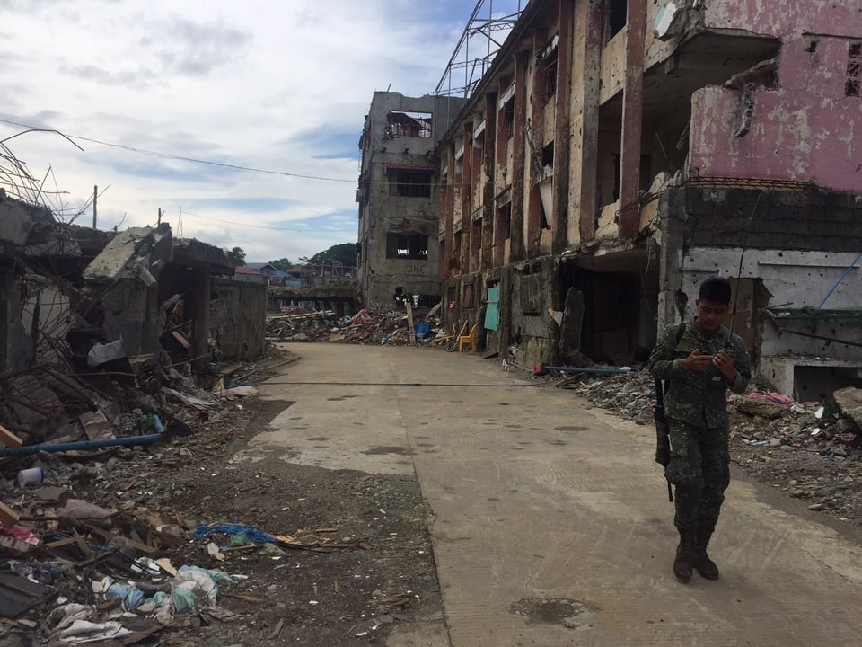 Soldat vor einer Gebäudefasse in Marawi