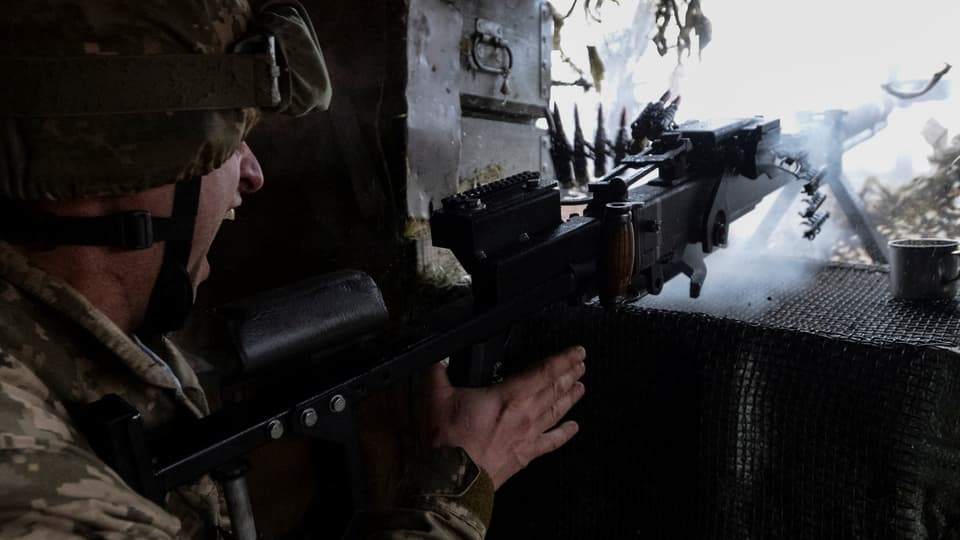 Ein ukranischer Soldat feuert mit seinem Maschinengewehr: