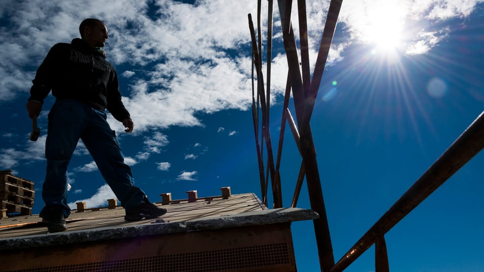 Ein Handwerker auf einem Dach.