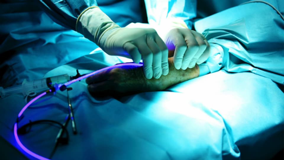 Im OP wird ein Arm im Blaulicht mit der neuen Methode behandelt.