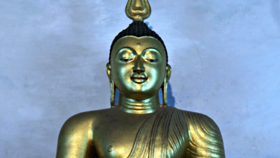 Sitzender goldener Buddha, fotografiert in Sri Lanka.