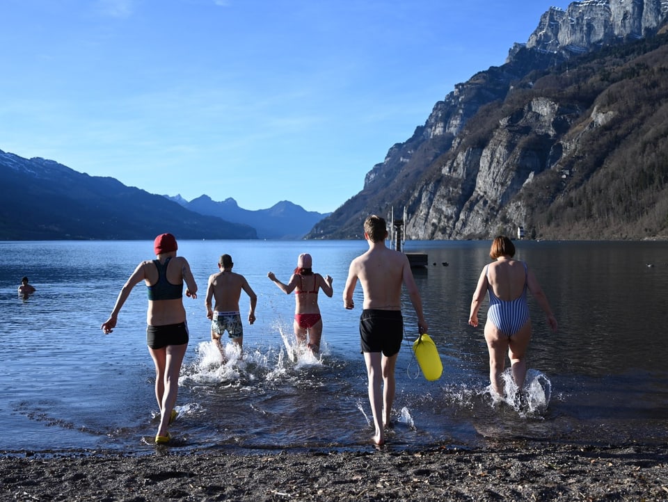 5 Menschen, die in einen See rennen.