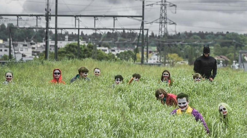 Nicolas Huber und Kinder verstecken sich in hohem Gras. 