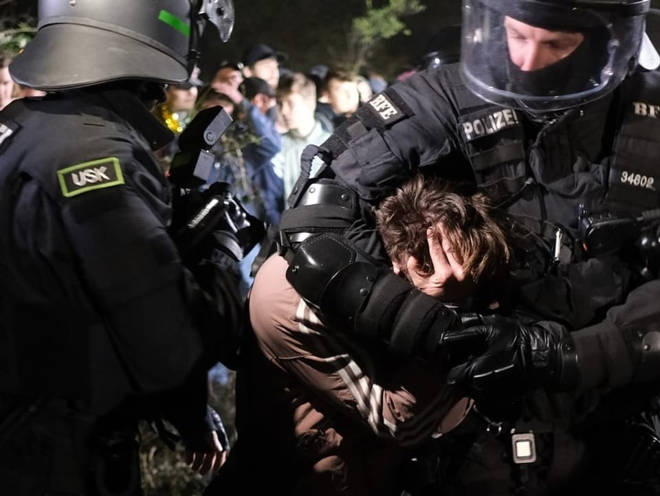 Polizisten nehmen an den Ausschreitungen im Stadtteil Connewitz einen Mann in Gewahrsam.