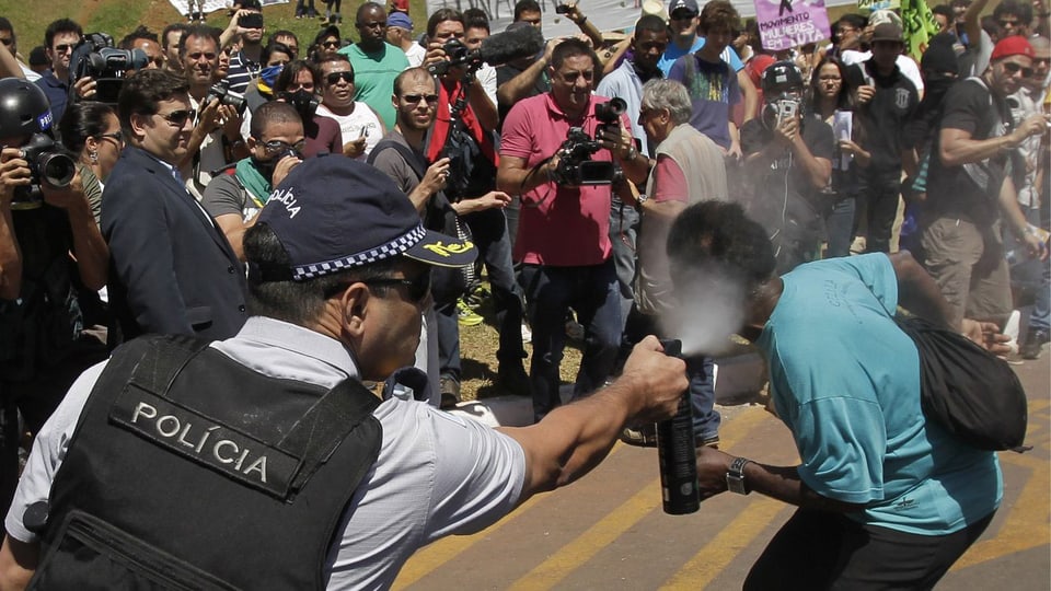 Polizist sprüht einem Demonstranten in Brasilia Pfefferspray ins Gesicht.