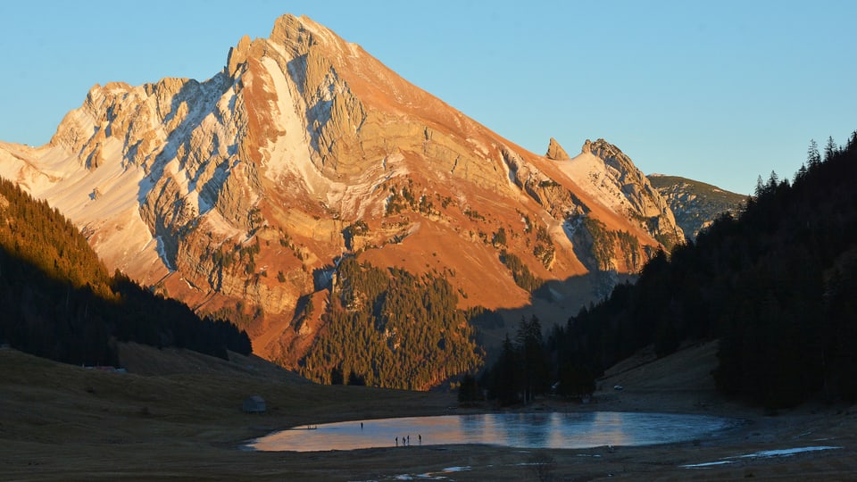 Das Alpsteinmassiv in der Abendsonne, darunter der gefrorene Gräppelensee.