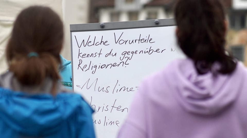 Zwei Mädchen stehen vor einer Wandtafel