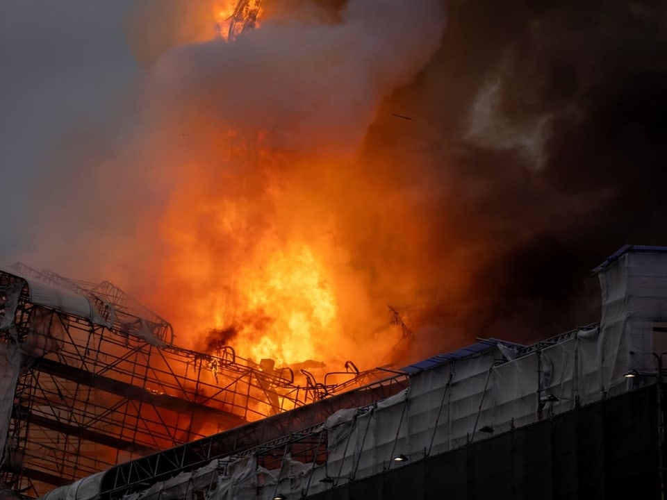 Grosses Feuer mit dichten Rauchwolken in einem Industriegebäude.