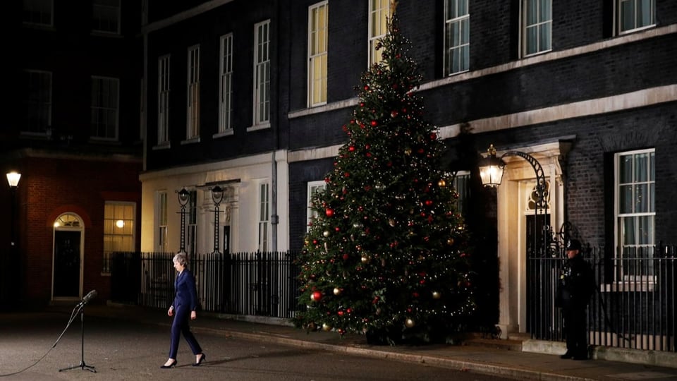 Theresa May verlässt 10 Downing Street. Neben dem Gebäude steht ein Weihnachtsbaum.