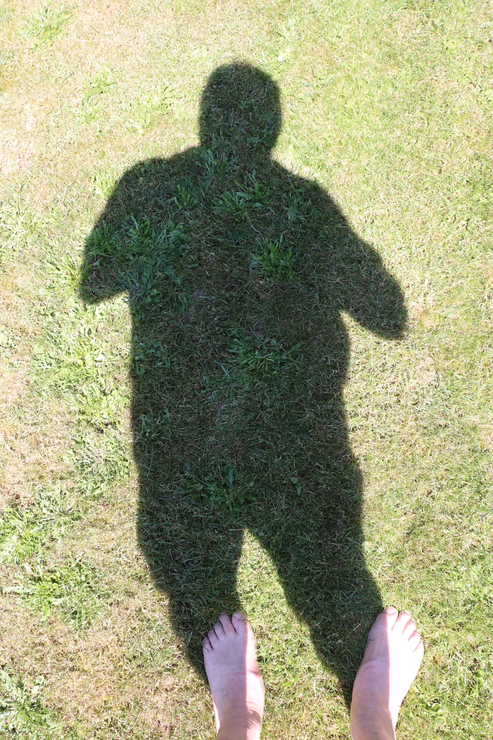 Bild mit echten Füssen und ganzem Schatten eines Fotographen.