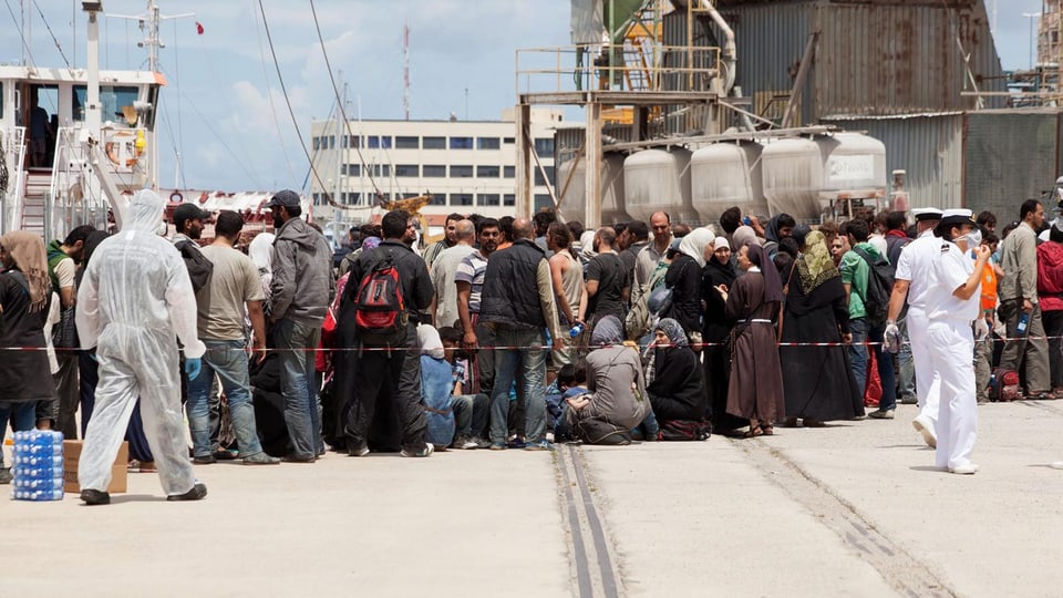 Flüchtlinge bei der Ankunft in einem Hafen.