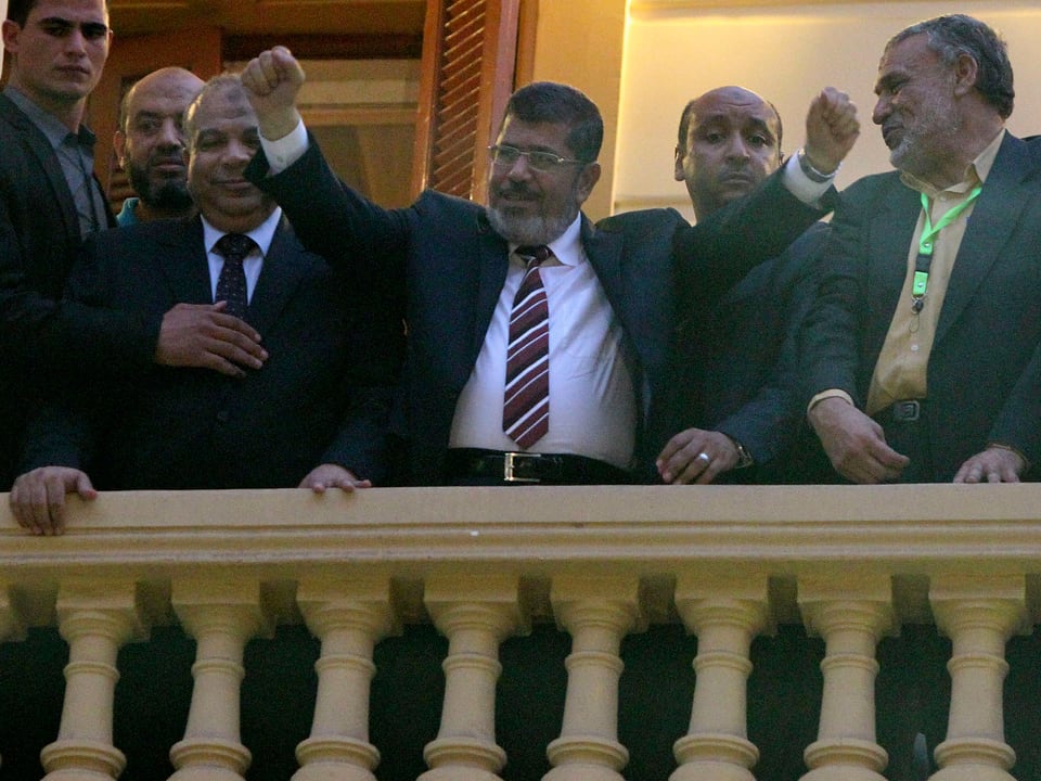 Mursi jubelt auf einem Balkon in die Menge