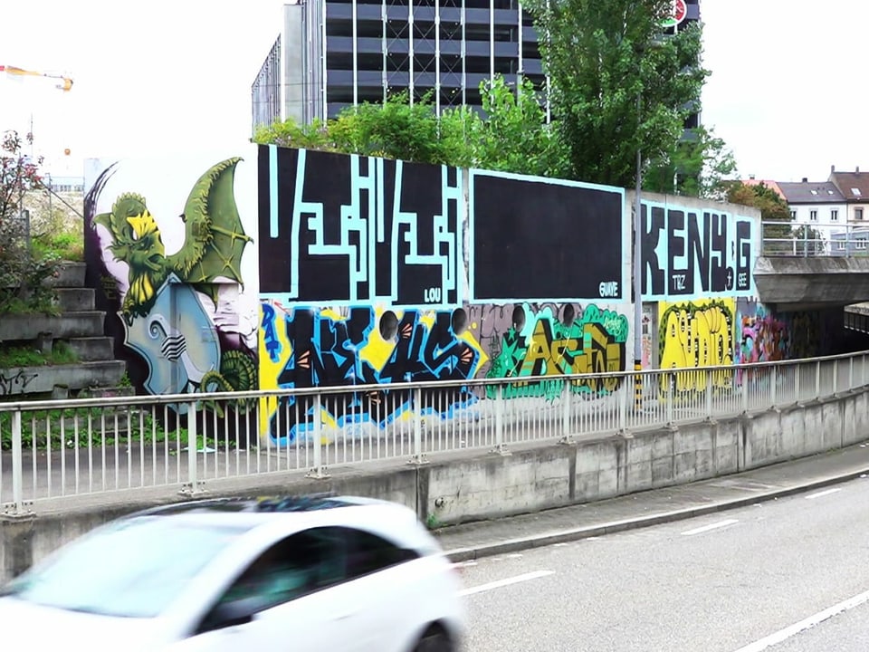 Unterführung mit fahrenden Autos, im Hintergrund Graffiti an den Wänden
