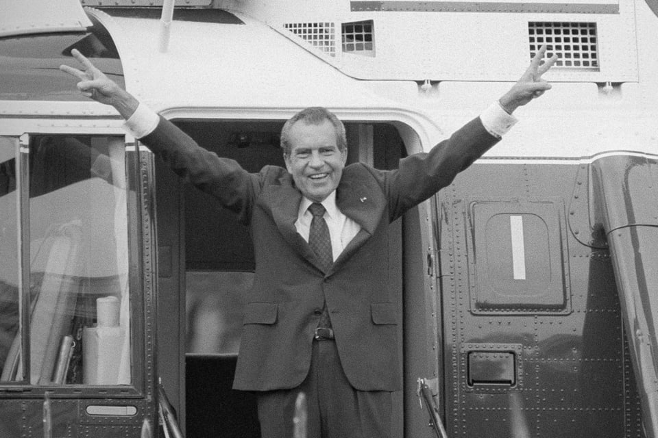 Richard Nixon mit ausgestreckten Armen und dem Victory-Zeichen beim Eingang eines Helikopters im August 1974.