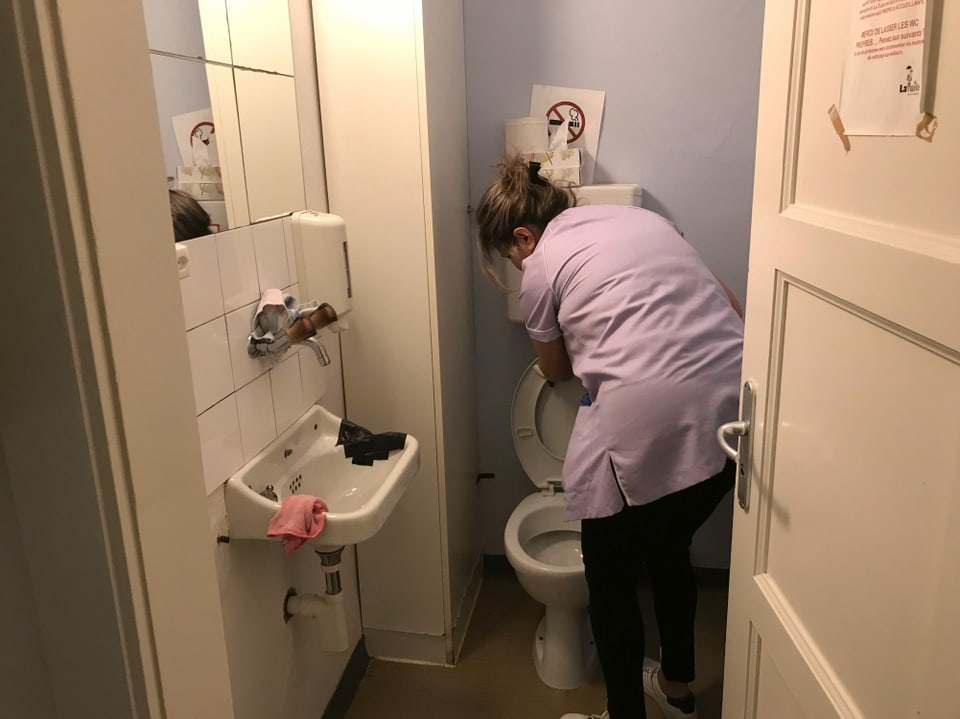 Frau putzt eine Toilette