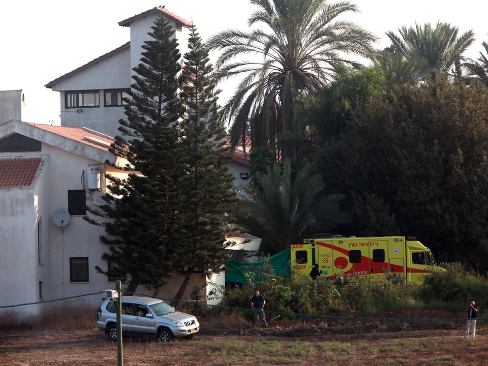 Ein Krankenwagen ist vor einem Landhaus abgestellt.