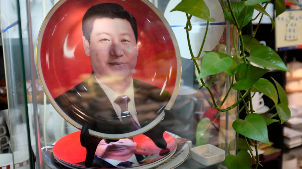 Teller mit dem Porträt Xis vor rotem Hintergrund.