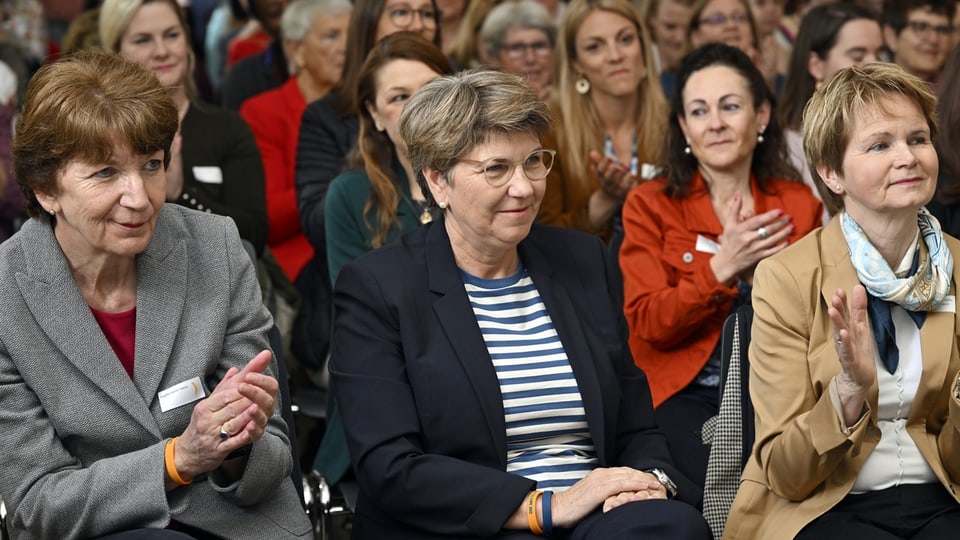 Zahlreiche Frauen sitzen auf Stühlen an einer Veranstaltung. Brigitte Hauser neben Bundesrätin Viola Amherd.